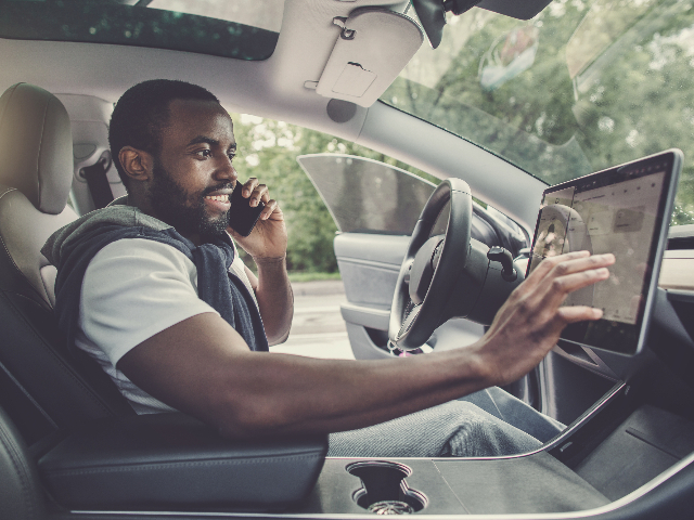 Connected Technologies Autonomous Mobility man in car with touch screen
