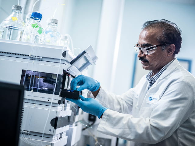 Man in lab coat working on a machine