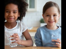 Two kids with glasses of drinking water tested with at-home testing kits from Element