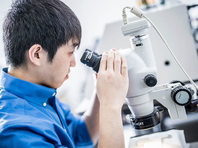 Scientist looking through microscope