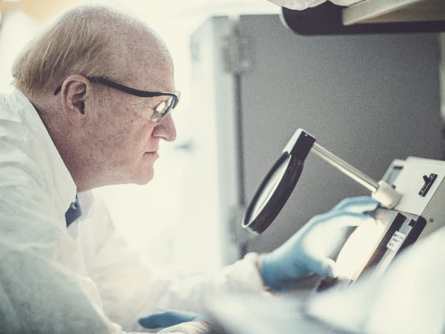 Man in white lab coat using equipment